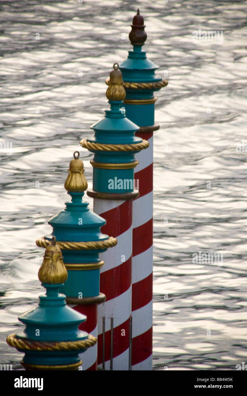 L'Europa, Italia e Venezia. Una linea di gondola poli di parcheggio a strisce in rosso e bianco. Foto Stock