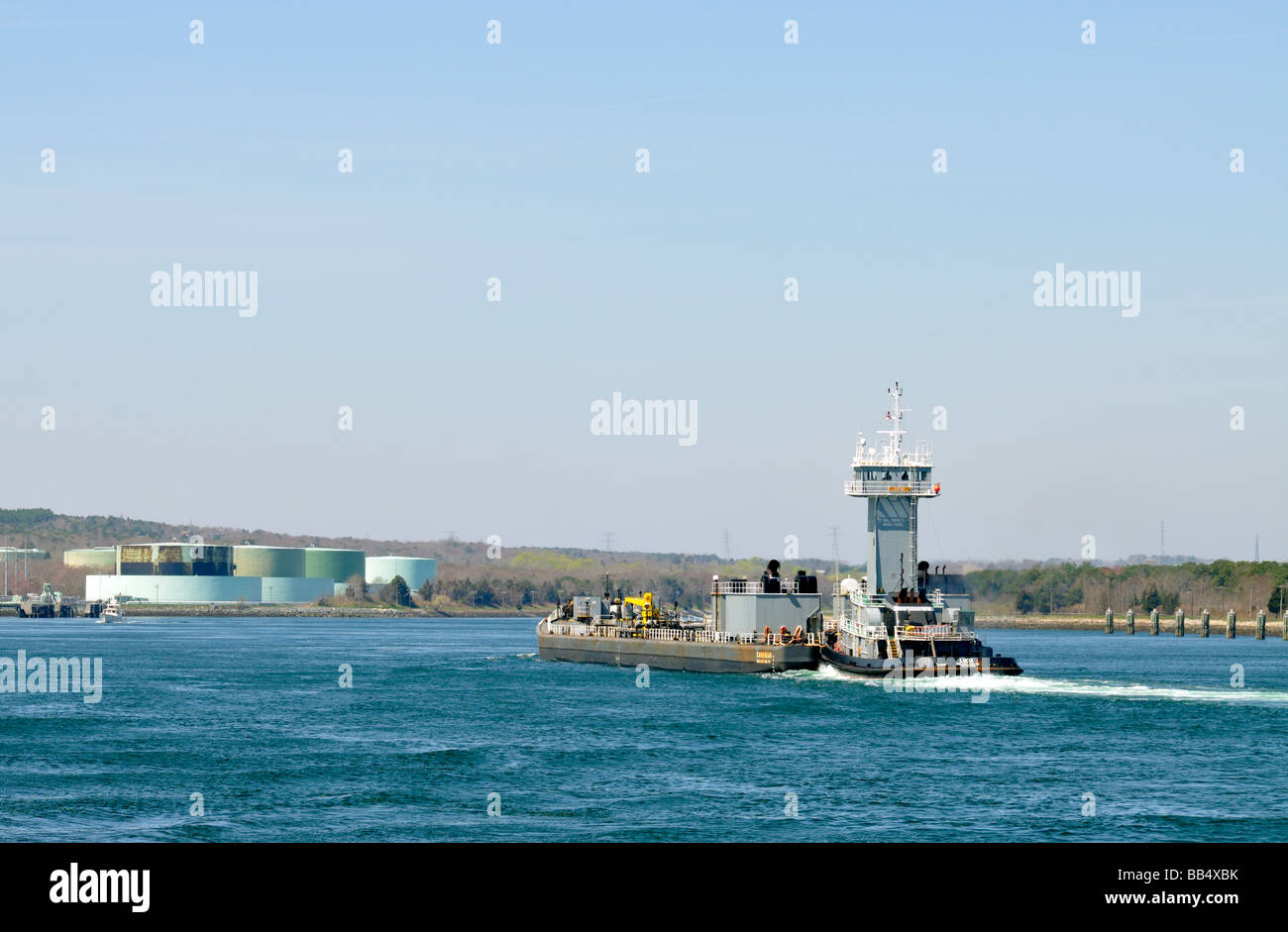 Olio combustibile barge nel canale di Cape Cod con terminali di serbatoi di stoccaggio al di là in Massachusetts, STATI UNITI D'AMERICA Foto Stock