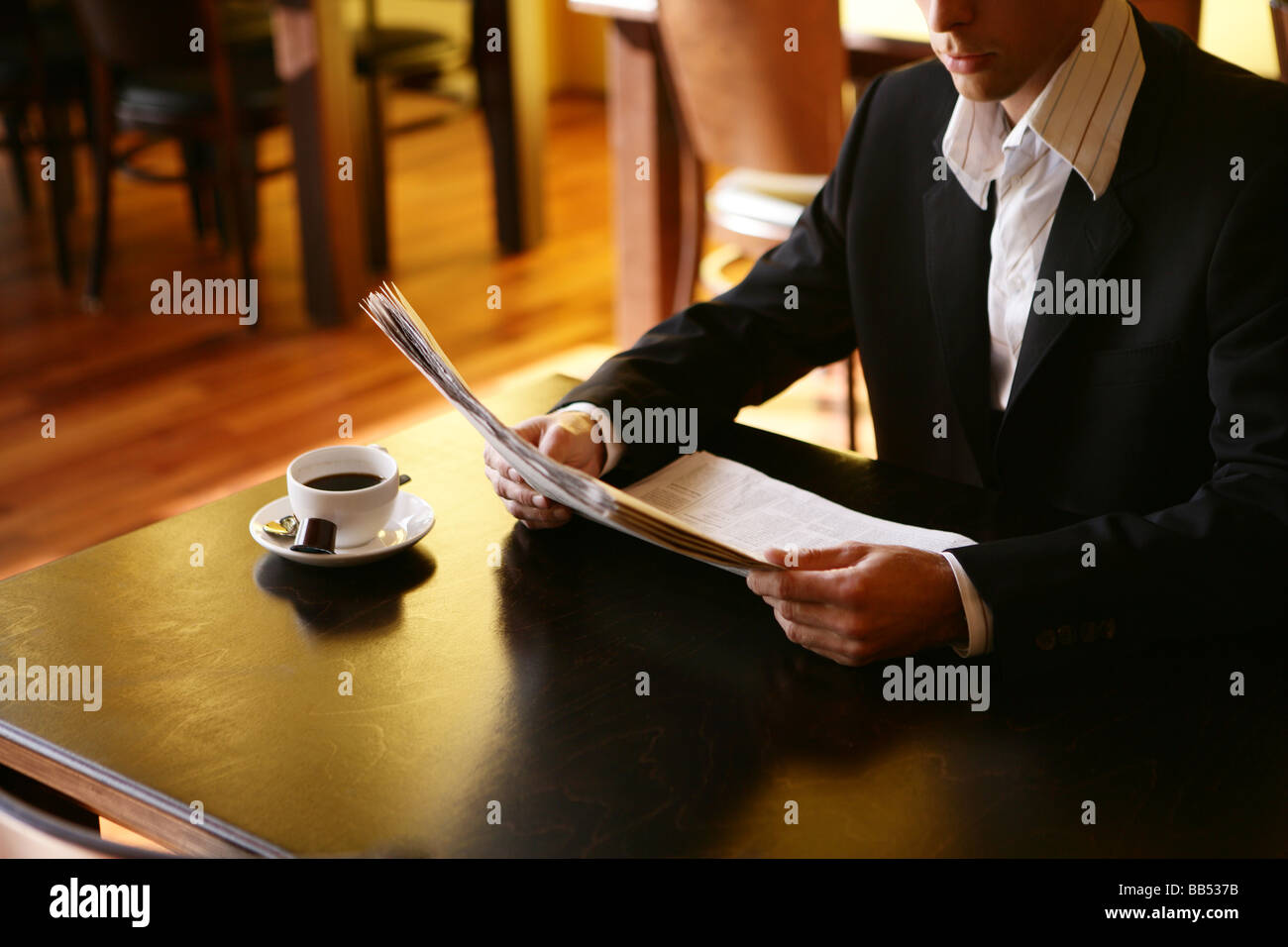 Giovane con un giornale in cafe Foto Stock