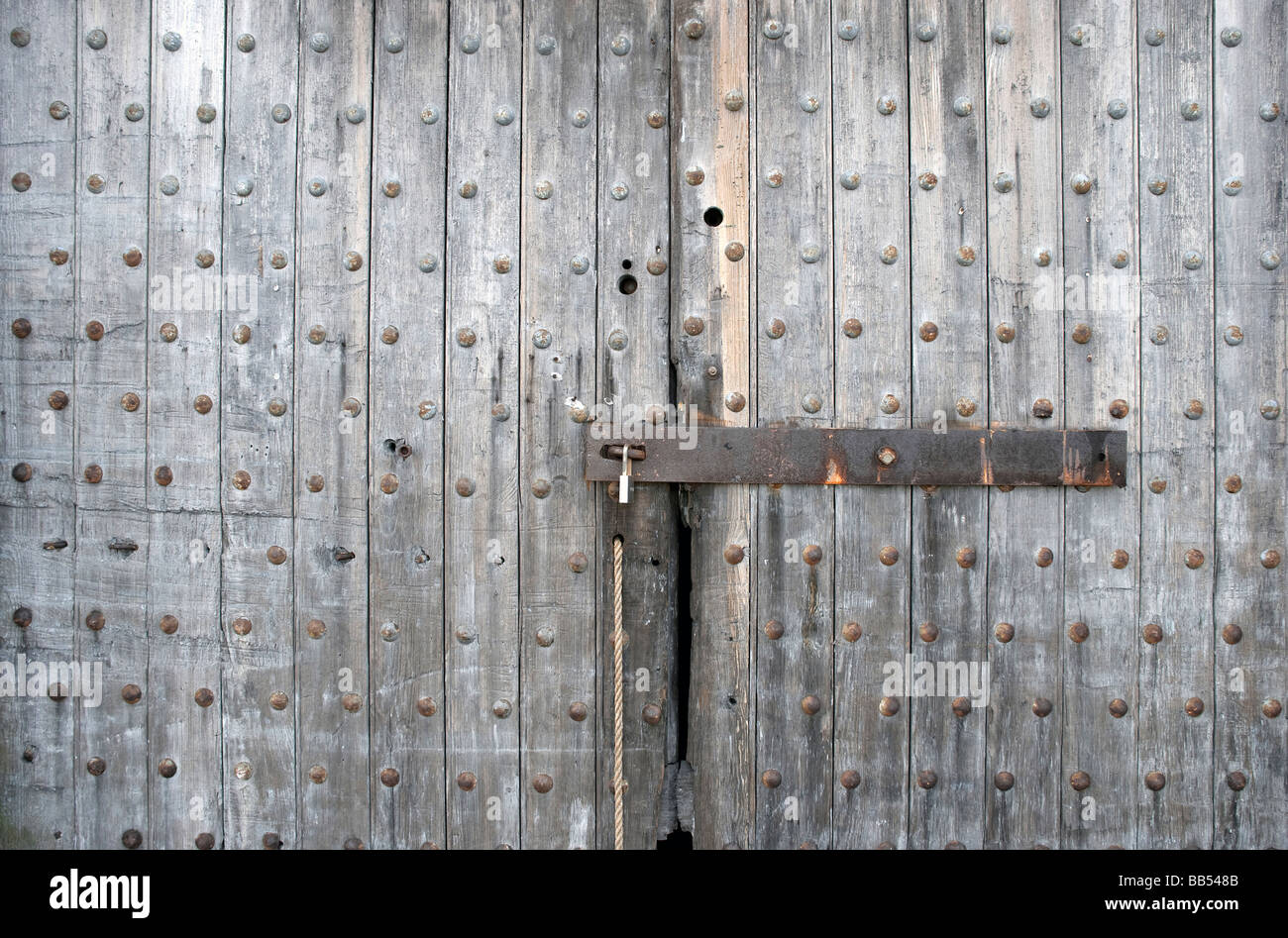 Vite di tavoloni porte fortezza ruvida barriera orizzontale squadrate robusto solido pesante pannello di legno rustico barra grigia weathered latch hasp vecchio Foto Stock