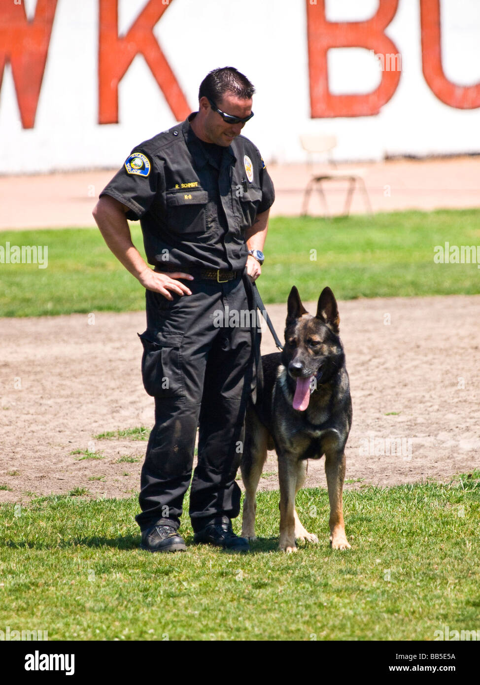 Funzionario di polizia e il suo cane poliziotto stand presso il pronto per la fase successiva di k9 prove. Foto Stock