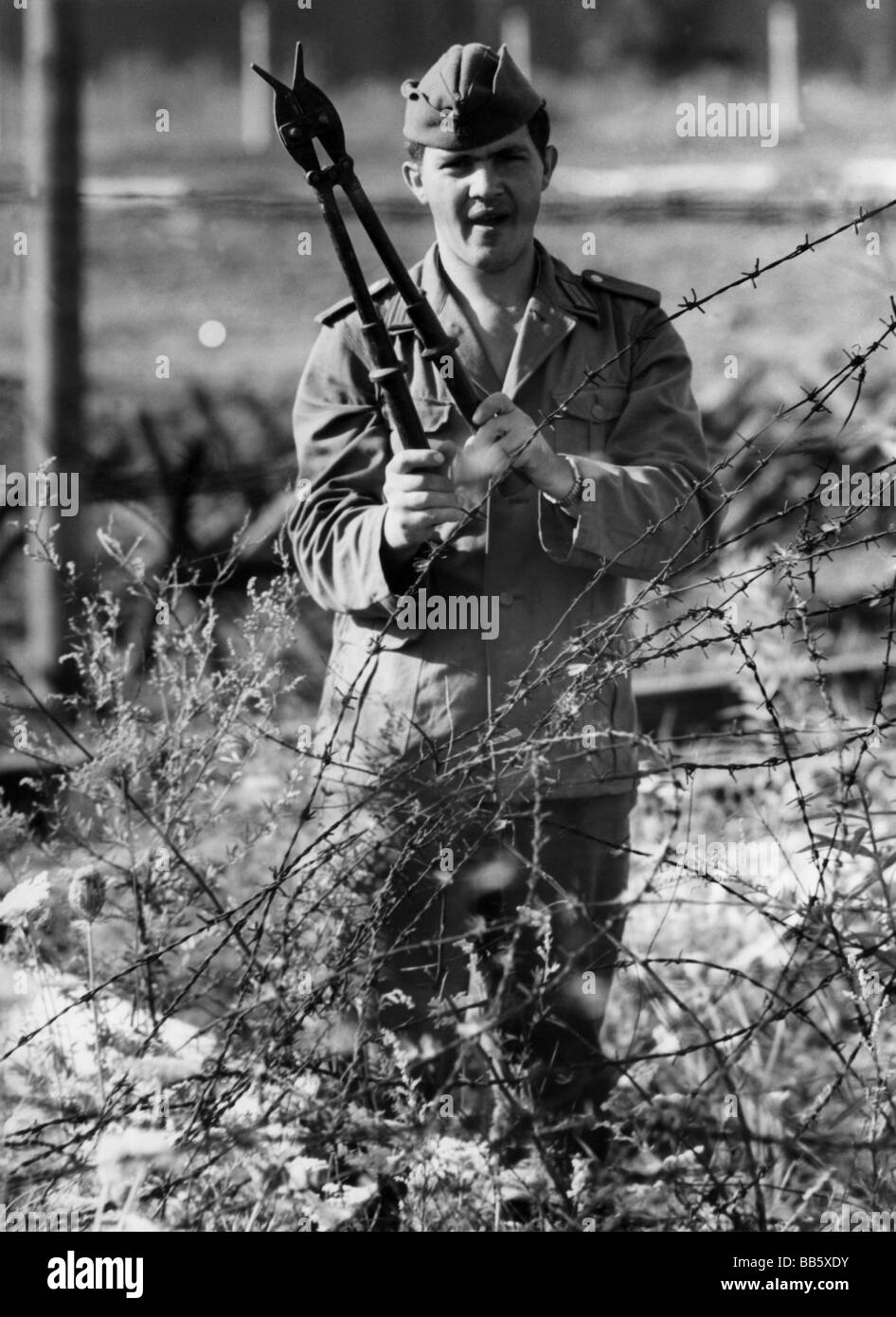 Militare, Germania orientale, Truppe Di Confine, soldato con cesoie metalliche, lavoro sulla barriera di confine, Berlino Est, circa 1965, Foto Stock