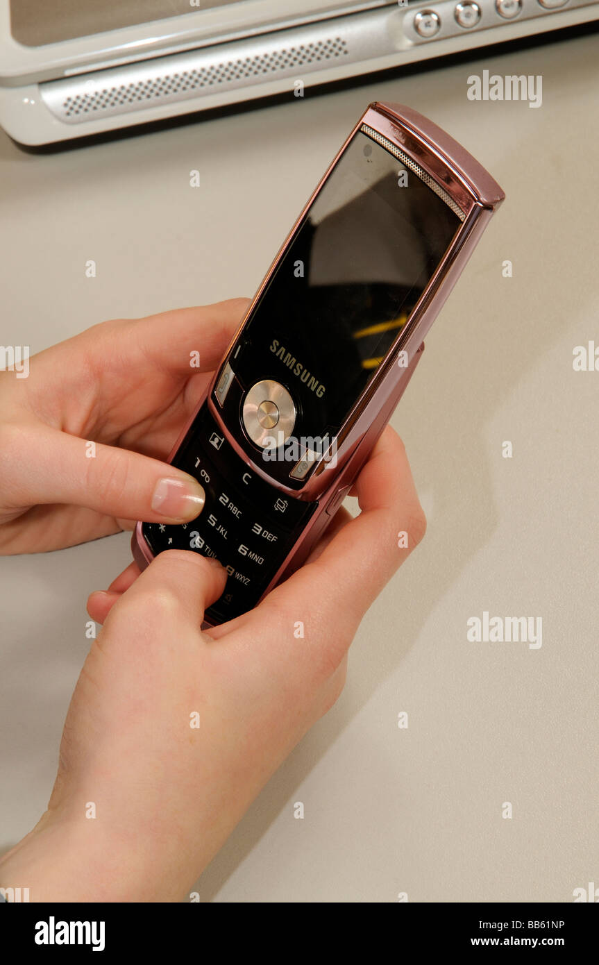 Schoolgirl utilizzando un telefono cellulare Foto Stock