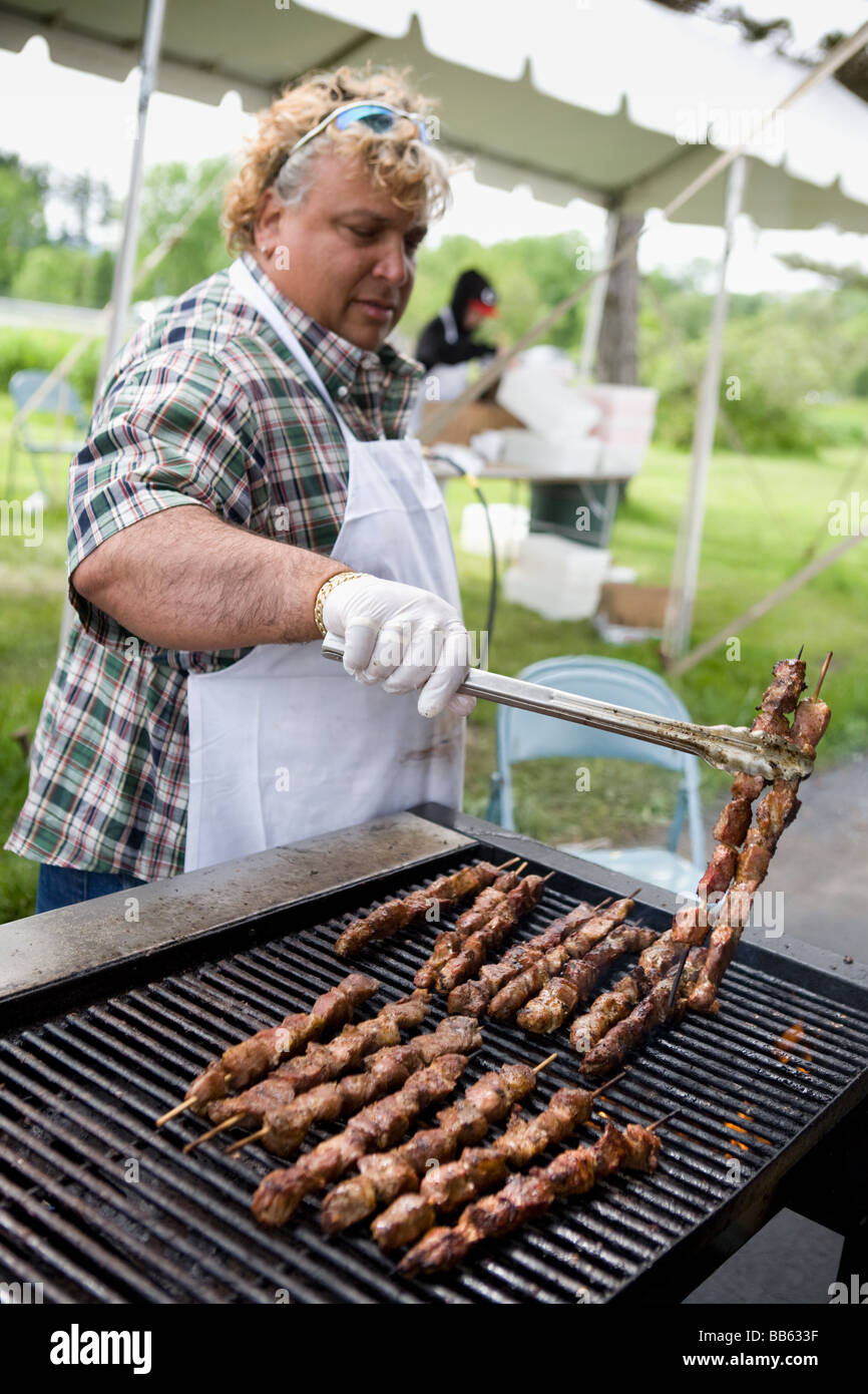Uomo di agnello di cottura sulla griglia per il souvlaki greco Festival Albany New York Foto Stock
