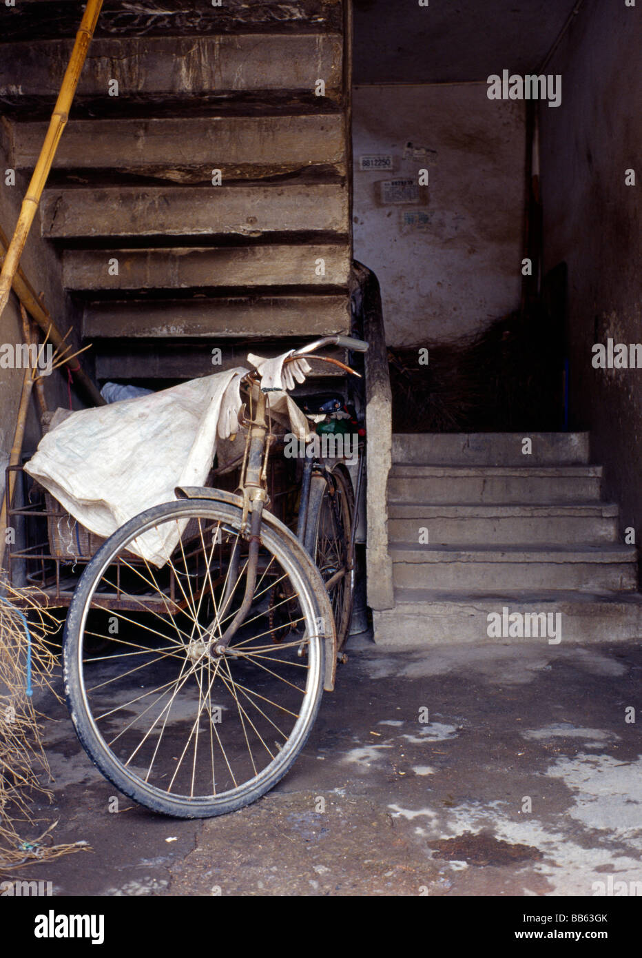 Vecchia bicicletta sotto le scale, Yangshau, Cina Foto Stock