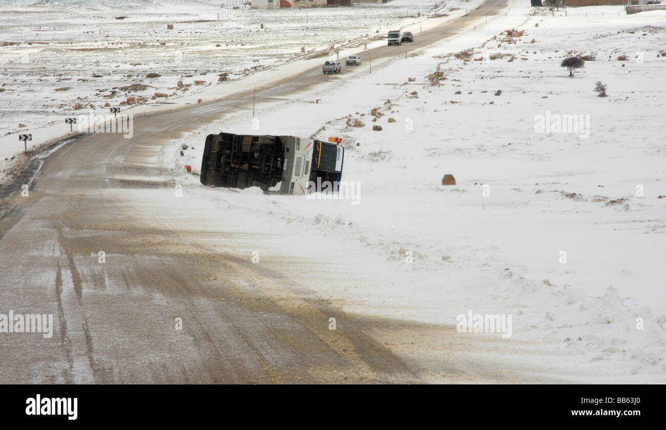 Rovesciato marocchino bus pubblico dal lato di una neve/ghiaccio su strada di montagna nel mezzo delle montagne Atlas, vicino a Ifrane, Marocco Foto Stock