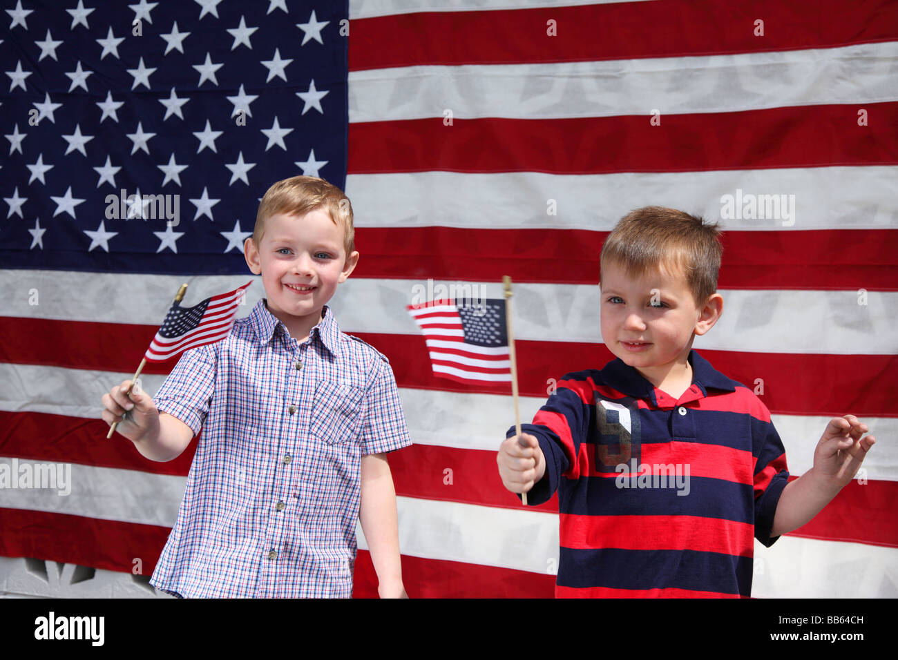 Due giovani ragazzi sventolando bandierine americane Foto Stock
