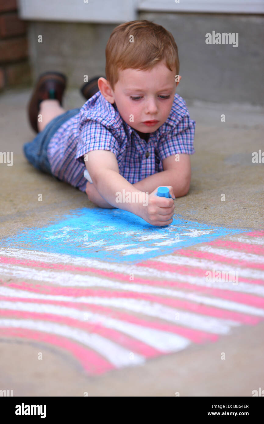 Ragazzo giovane Disegno bandiera americana sul marciapiede con Chalk Foto Stock