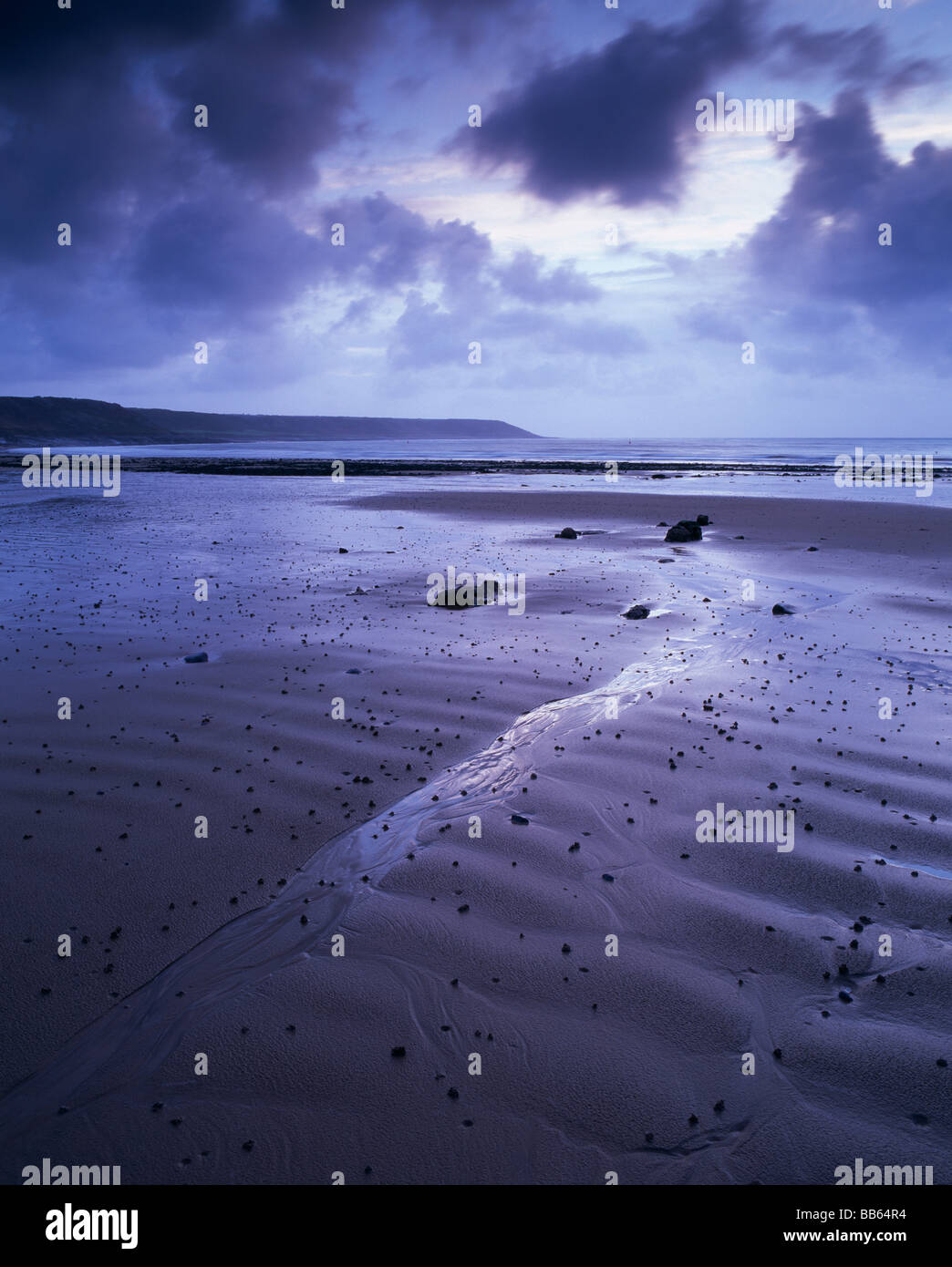 Nel Regno Unito, in Galles, Port Eynon (Gower). Increspature di sabbia sulla spiaggia poco dopo l'alba su un giorno blustery. Foto Stock