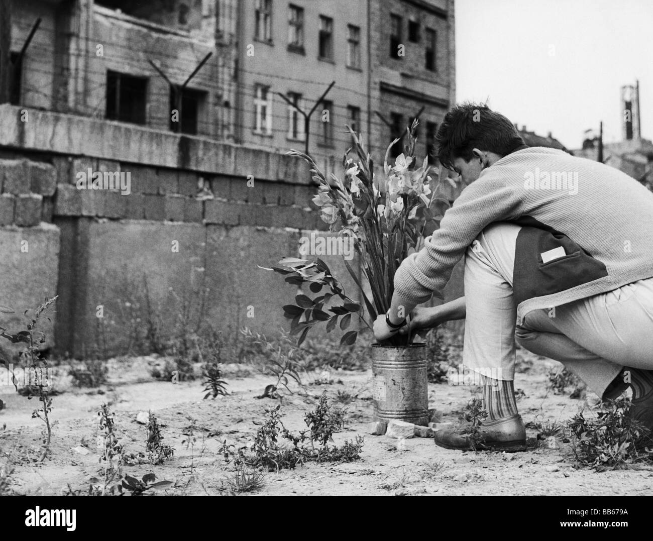 Geografia / viaggio, Germania, Berlino, muro, giovane uomo che depone i fiori nel luogo dove è stato girato un escapee della Germania orientale, Zimmerstrasse, 18.8.1962, Foto Stock