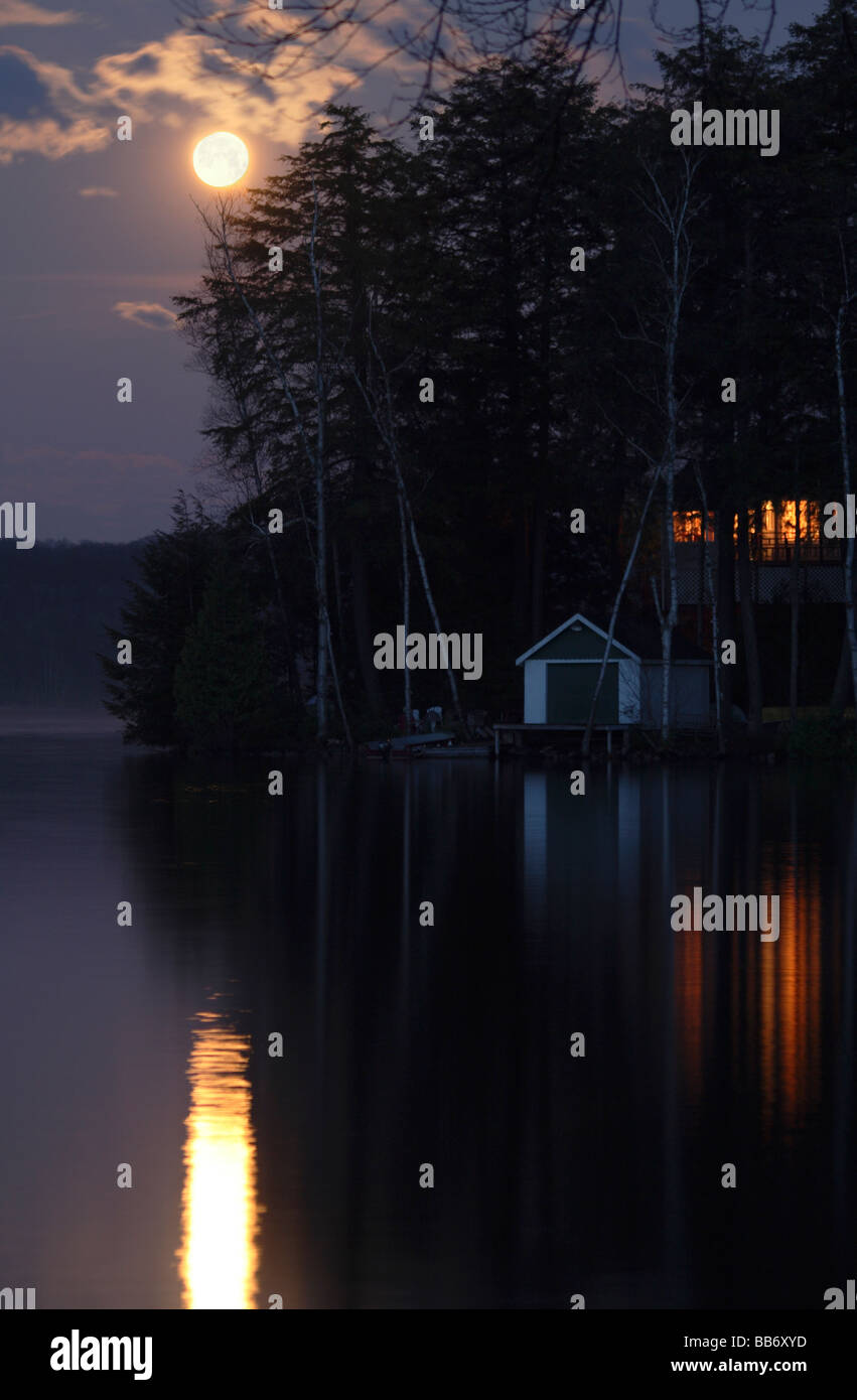 Cottage e casa-barca sotto la luna piena sul lago in Haliburton Ontario Foto Stock