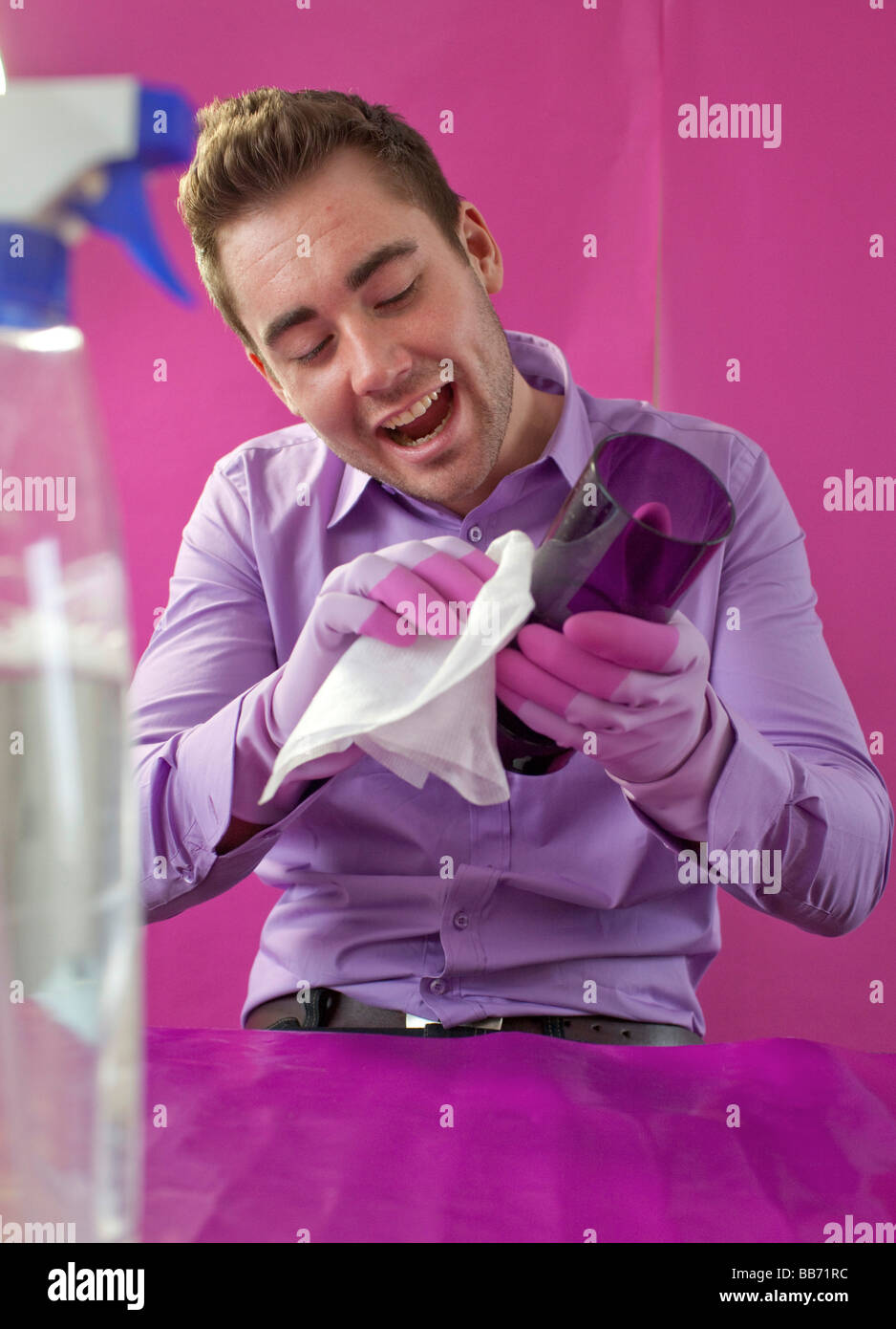 Giovane uomo che pulisce un vetro Foto Stock