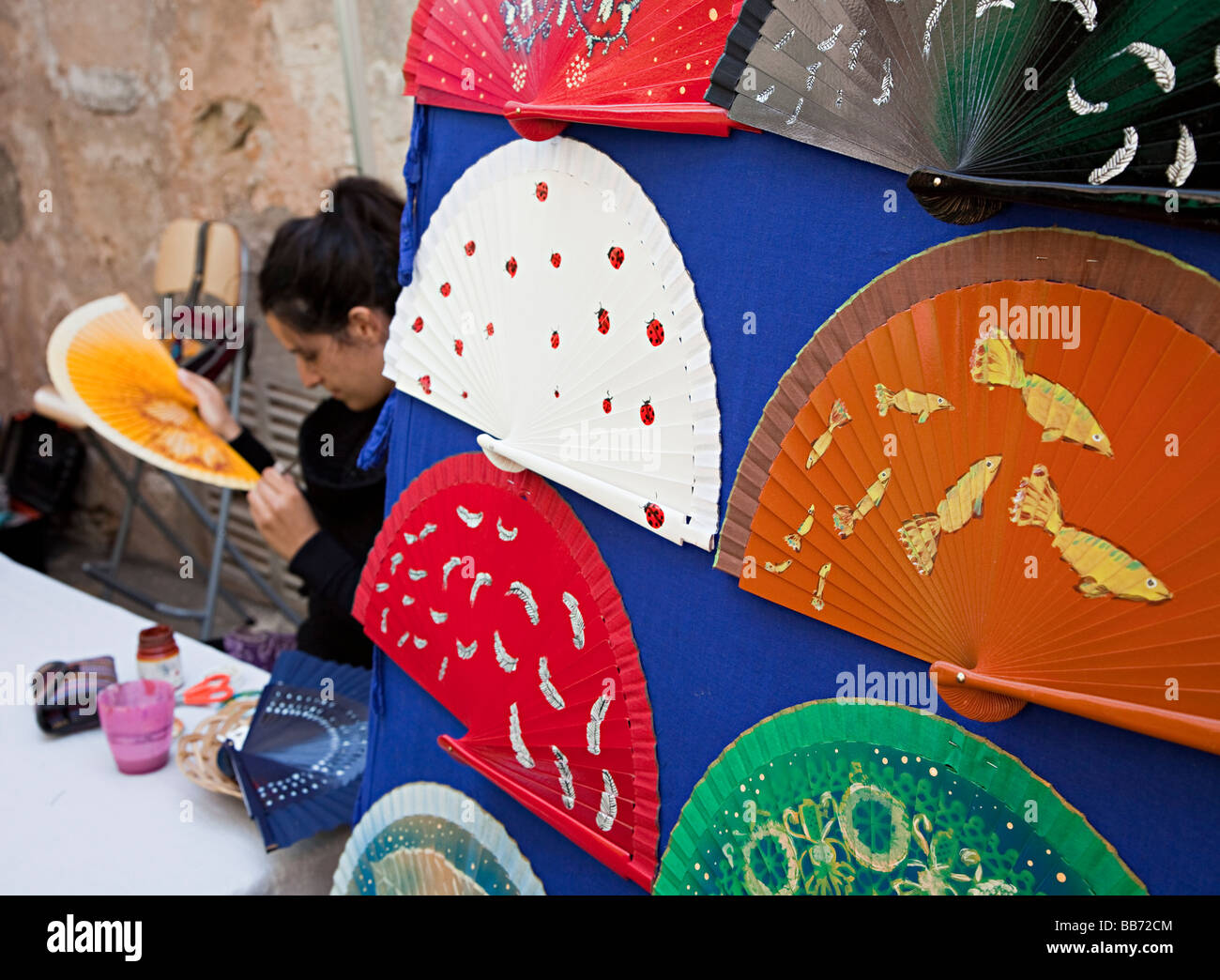 Donna spagnola dipinto a mano ventole nel mercato aperto, Sineu Mallorca Spagna Spain Foto Stock