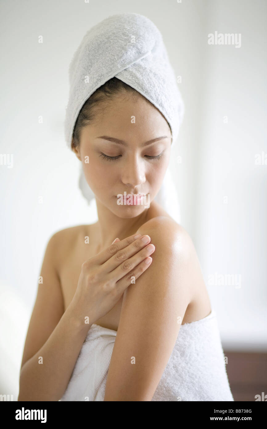 Donna l'applicazione di crema idratante in camera da letto Foto Stock