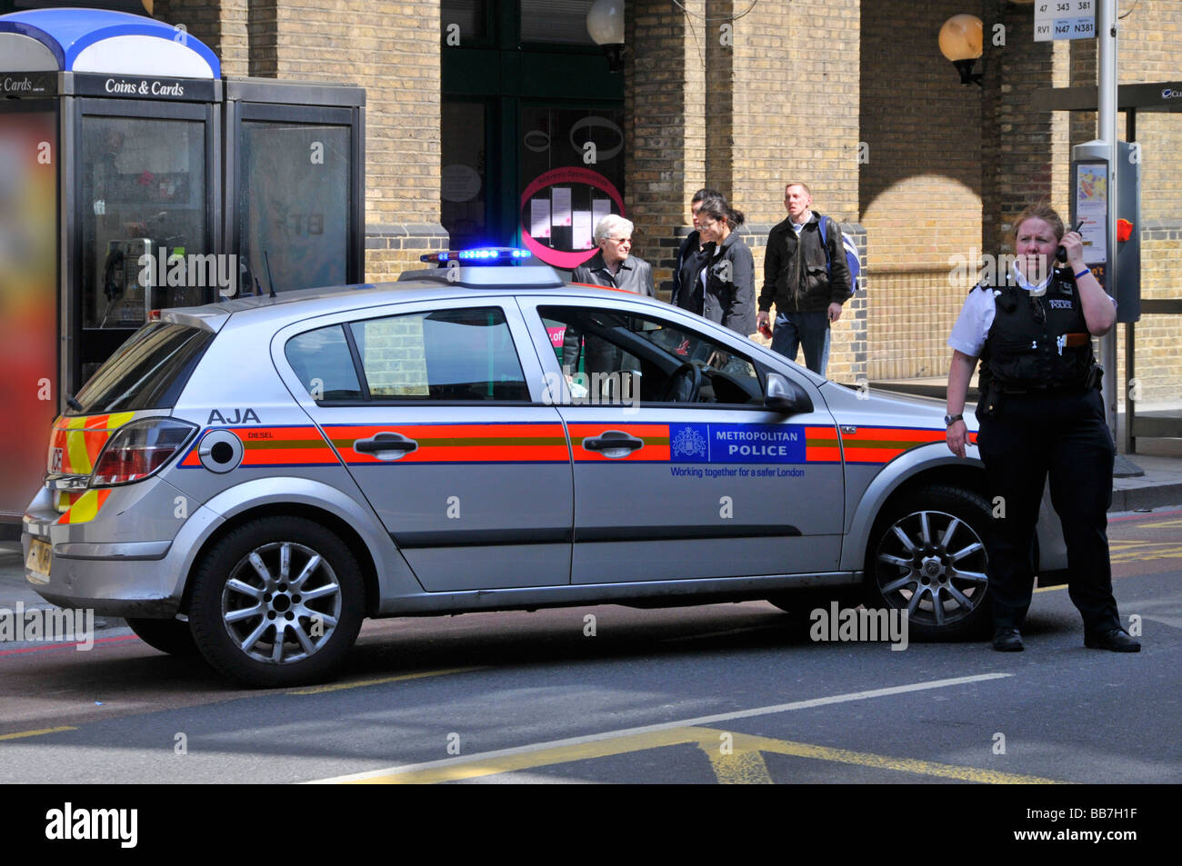 Poliziotta accanto a auto della polizia. controllare il traffico durante un incidente Foto Stock