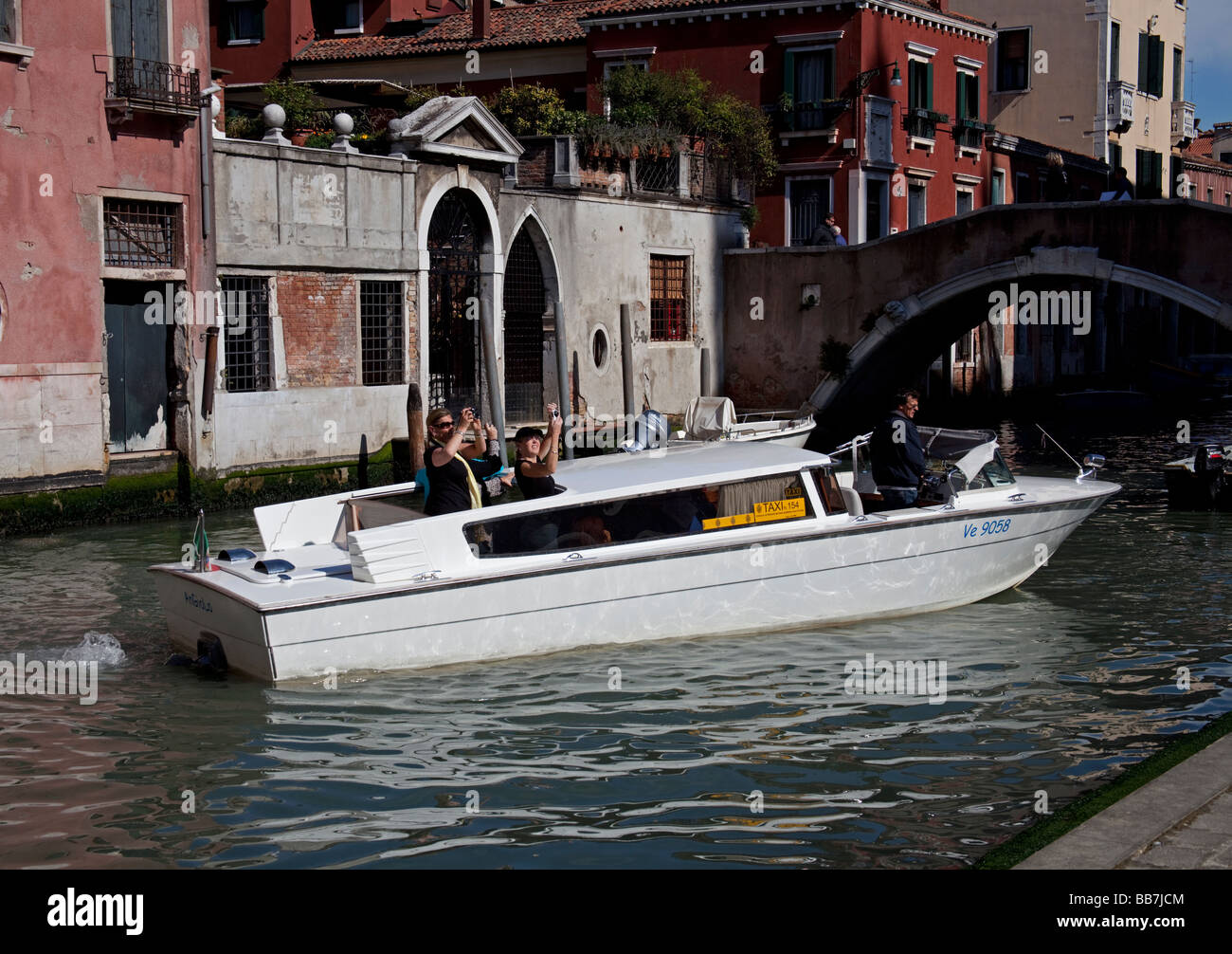 I turisti in taxi boat scattare fotografie di architettura Foto Stock