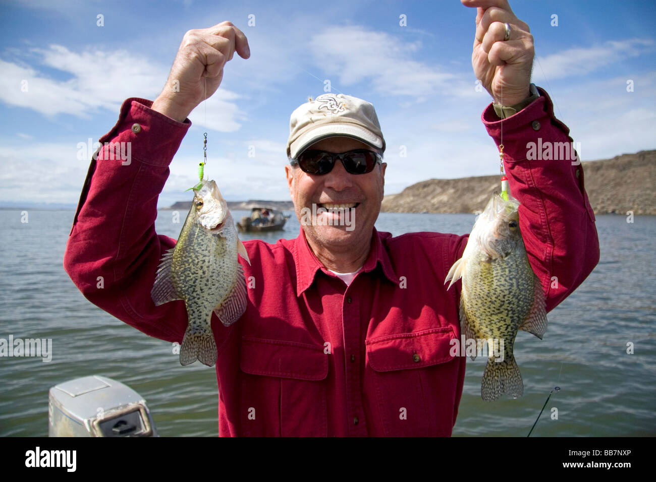 Orgoglioso pescatore con in mano una coppia di crappie bianco catturato in C J colpire il serbatoio sul fiume Snake in Owyhee County Idaho USA Foto Stock