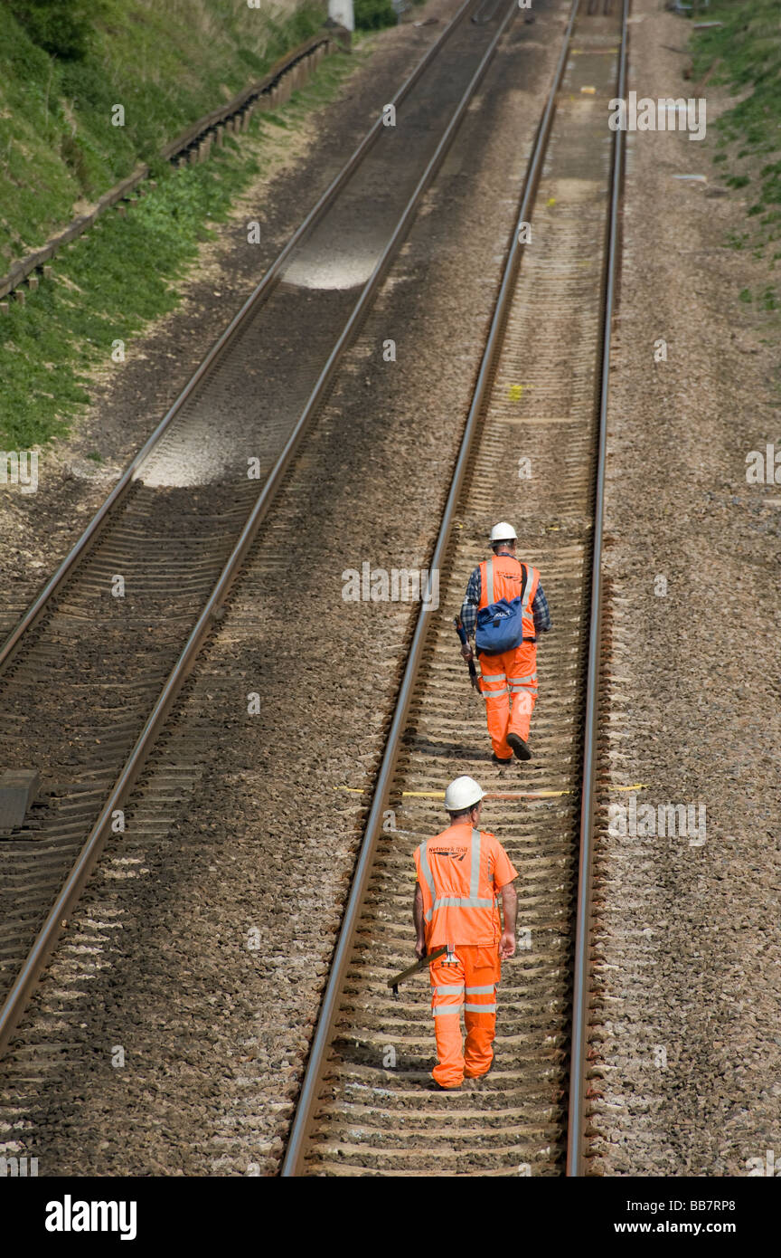 I lavoratori del settore ferroviario da rete guida camminando lungo il binario in Inghilterra Foto Stock