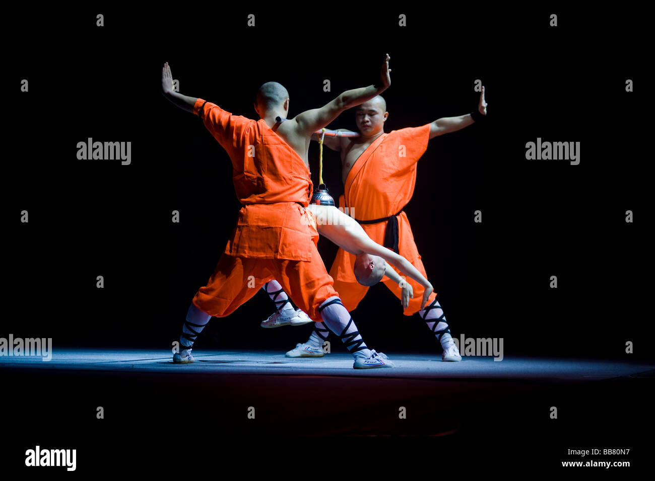 La concentrazione è di mantenere il vuoto nella campana, permettendo al bambino di appendere la fune, Shaolin Monks durante una mostra su Foto Stock