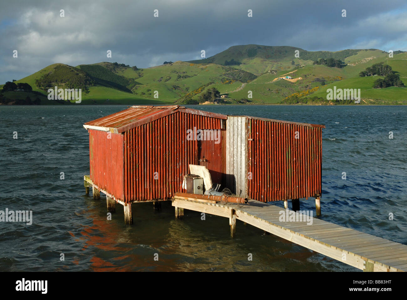Un rosso boathouse in ingresso Hoopers, Penisola di Otago, Nuova Zelanda Foto Stock