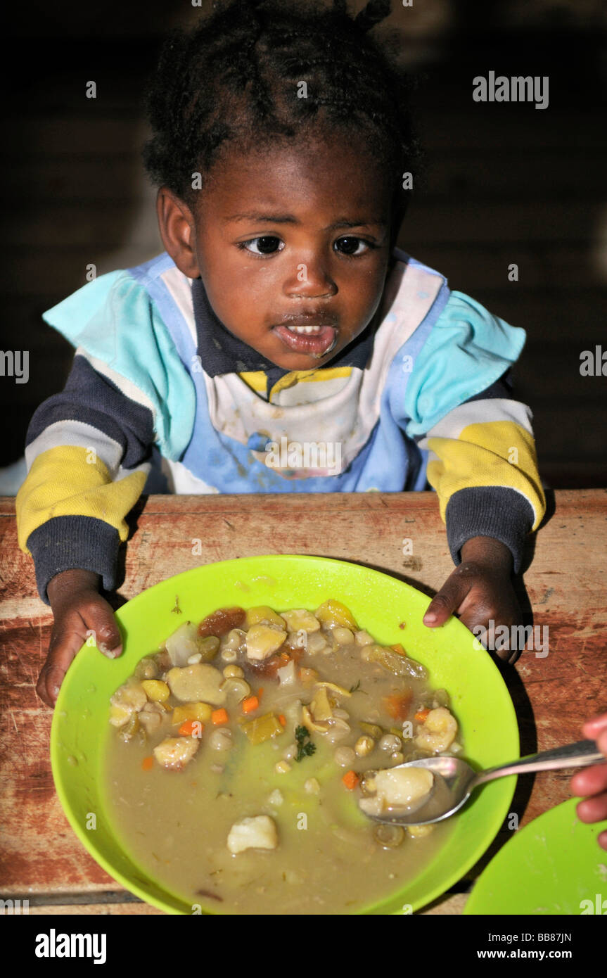 Piccolo, scuro spellate, cross-eyed girl in una zuppa di cucina, baraccopoli di Alto de Cazuca, Soacha, Bogotá, Colombia Foto Stock