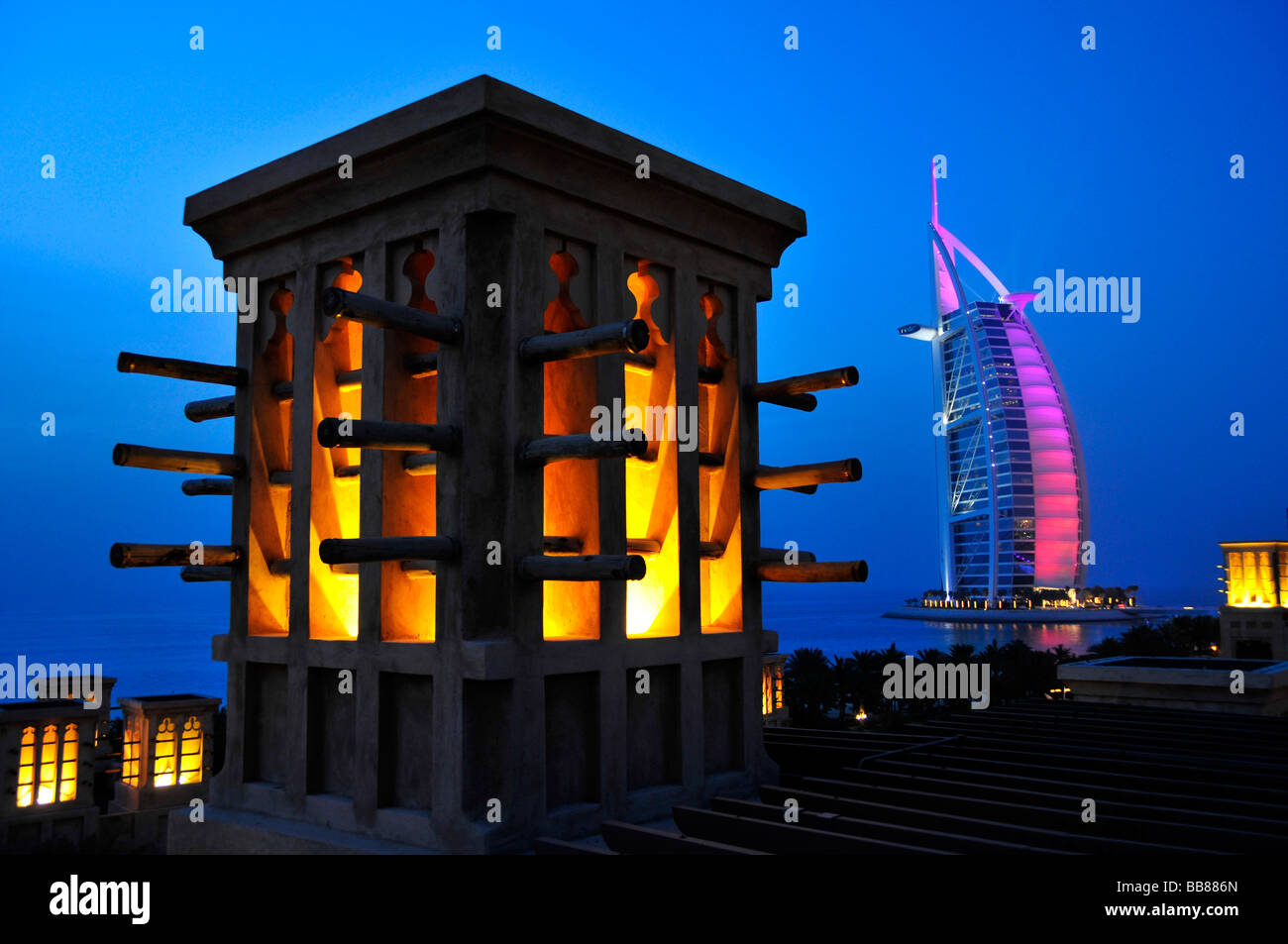Stilizzata torre eolica del Madinat Jumeirah resort di fronte alla facciata illuminata delle sette stelle Burj al Arab, Ara Foto Stock