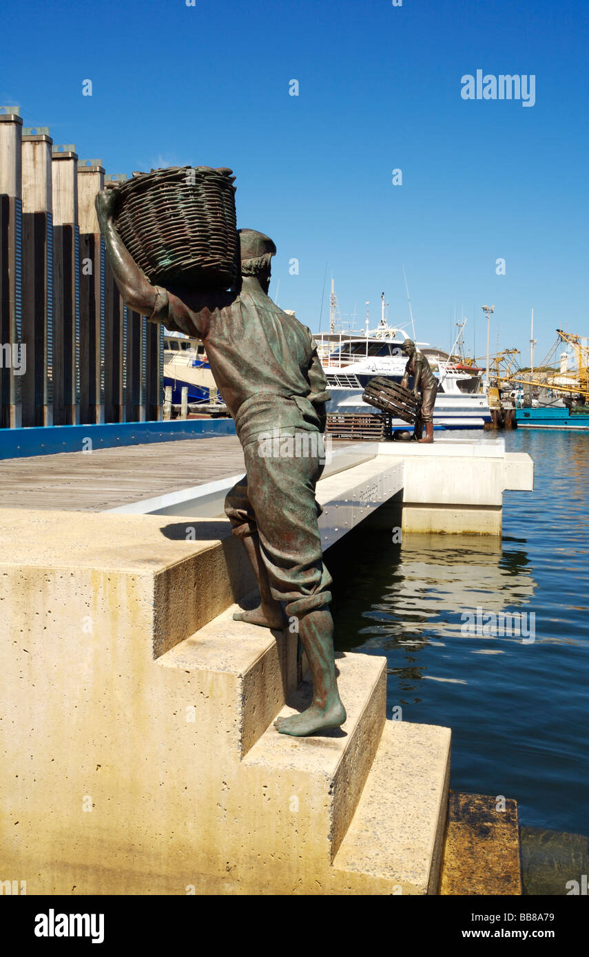 Statua di un pescatore che porta un cesto di pesce sulla banchina del Fishing Boat Harbour di Fremantle, Australia occidentale Foto Stock