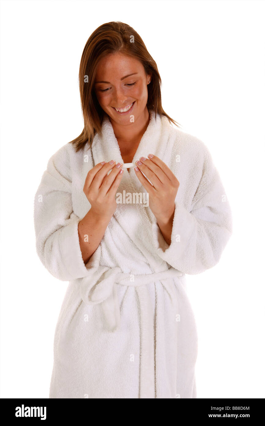 Femmina attraente tenendo un test di gravidanza cercando felice Foto Stock