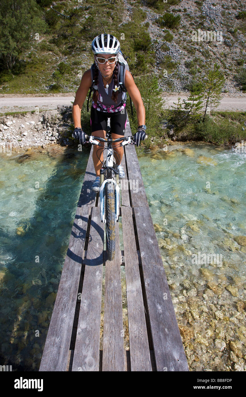 Una donna che attraversa uno stretto ponte di legno sul fiume Isar, a sud-est di Scharnitz, Tirolo, Austria, Europa Foto Stock