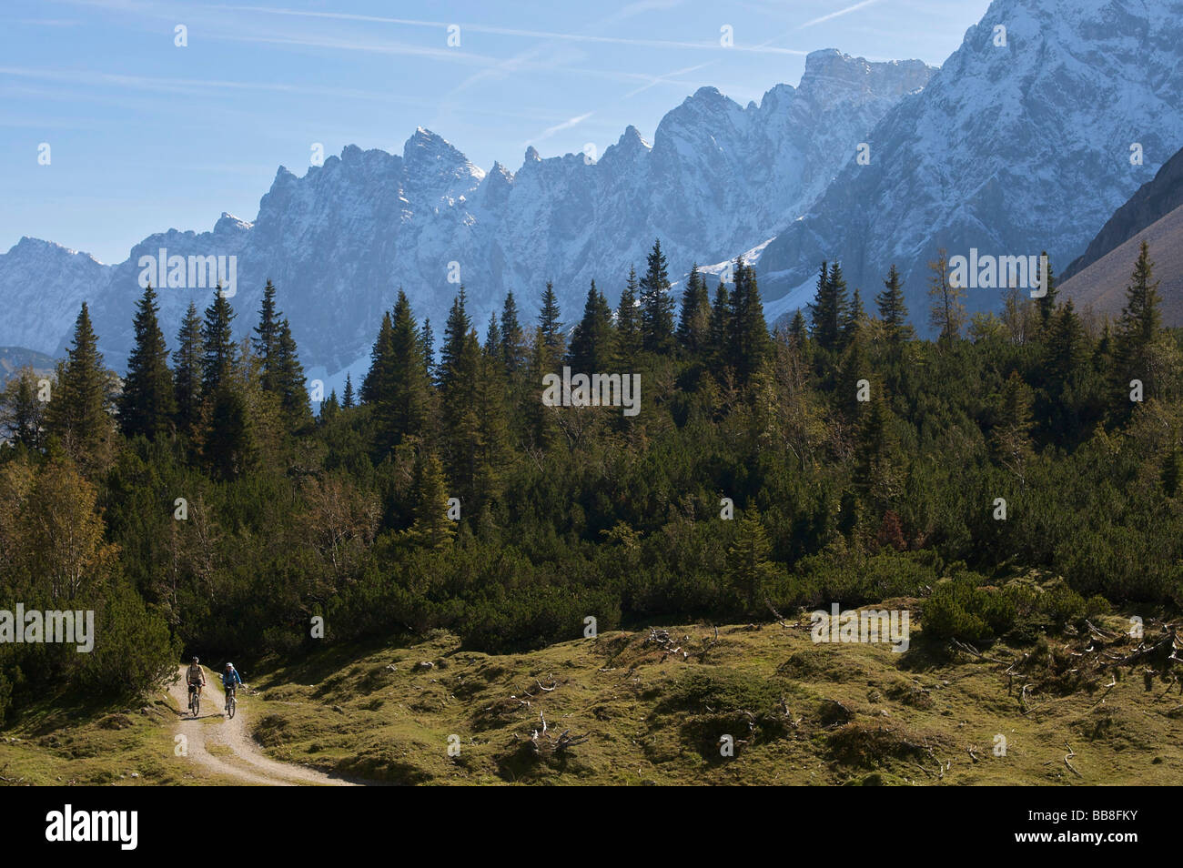 Mountainbike riders, maschio e femmina tra Karwendelhaus, alpine club house e Kleiner Ahornboden distretto forestale, Hinterri Foto Stock