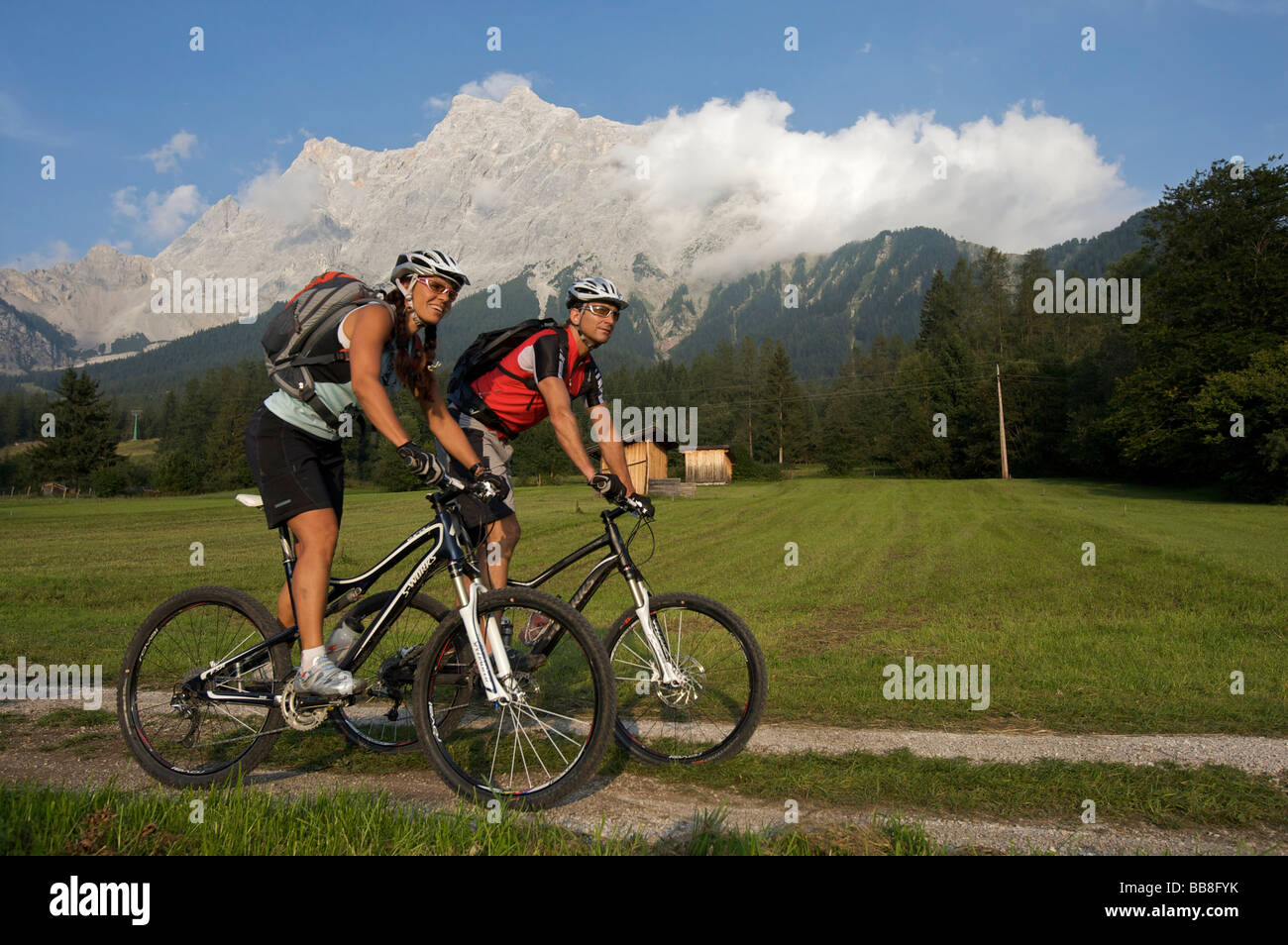 Maschio e femmina mountainbike piloti davanti a monte Zugspitze vicino a Ehrwald, Alta Baviera, Baviera, Germania, Europa Foto Stock