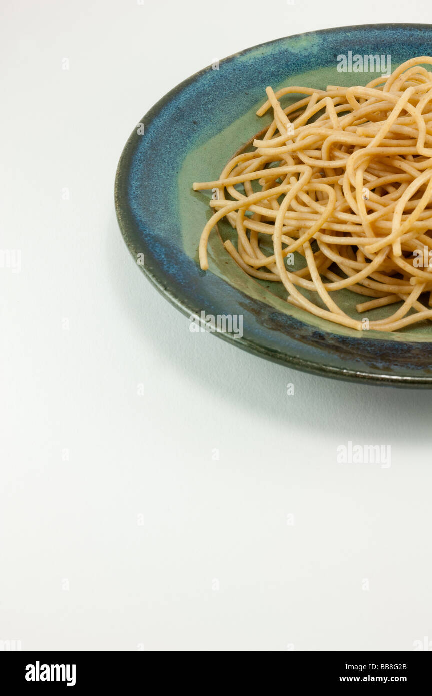Vista parziale di tutta la pasta di grano in una piastra di ceramica isolata su bianco Foto Stock
