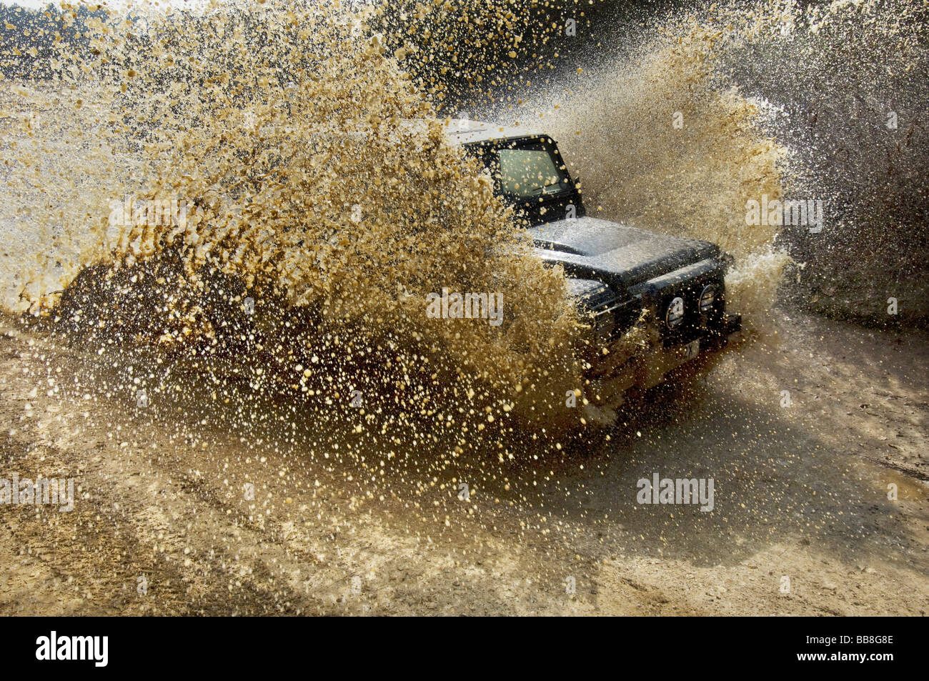 Un Landrover Defender guida attraverso un diluvio su una strada fuori esercizio Foto Stock