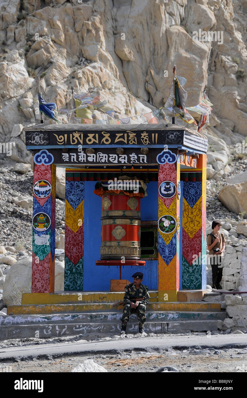 Soldato indiano in Hunder davanti a una preghiera buddista nella ruota anteriore della zona soggetta a restrizioni verso il Pakistan, Nubra Valley, in Foto Stock