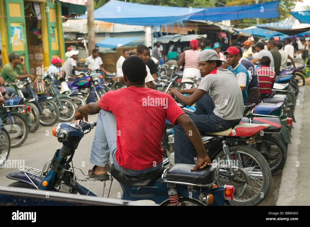 Motociclo taxi in attesa per il passeggero al mercato di strada; Neiba, Baoruco, Repubblica Dominicana Foto Stock