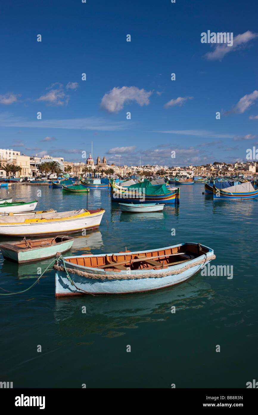 Tradizionali barche da pesca maltesi, chiamato Luzzu, di fronte alla chiesa della Madonna di Pompei, porto di Marsaxlokk, Malta, Euro Foto Stock