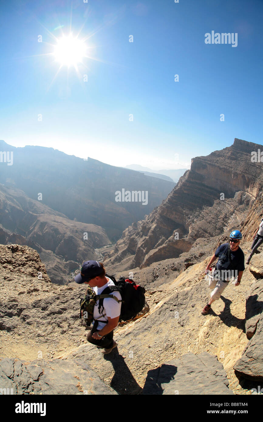 Un gruppo di turisti escursioni dal plateau superiore al fondo del Jebel Shams in Oman Foto Stock