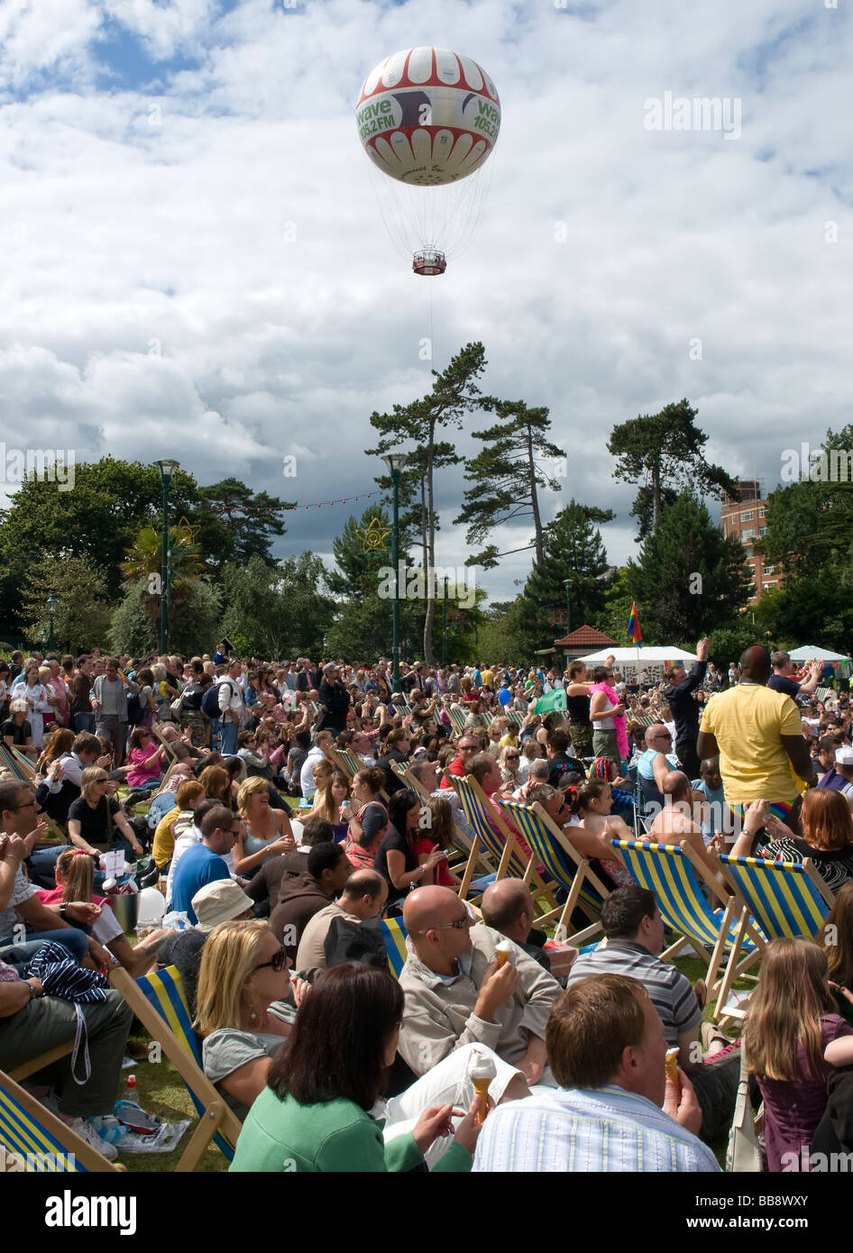 La folla si radunano in Giardini inferiori di Bournemouth per il Gay Pride Festival 2008 con l'onda FM pallone galleggiante in lontananza Foto Stock