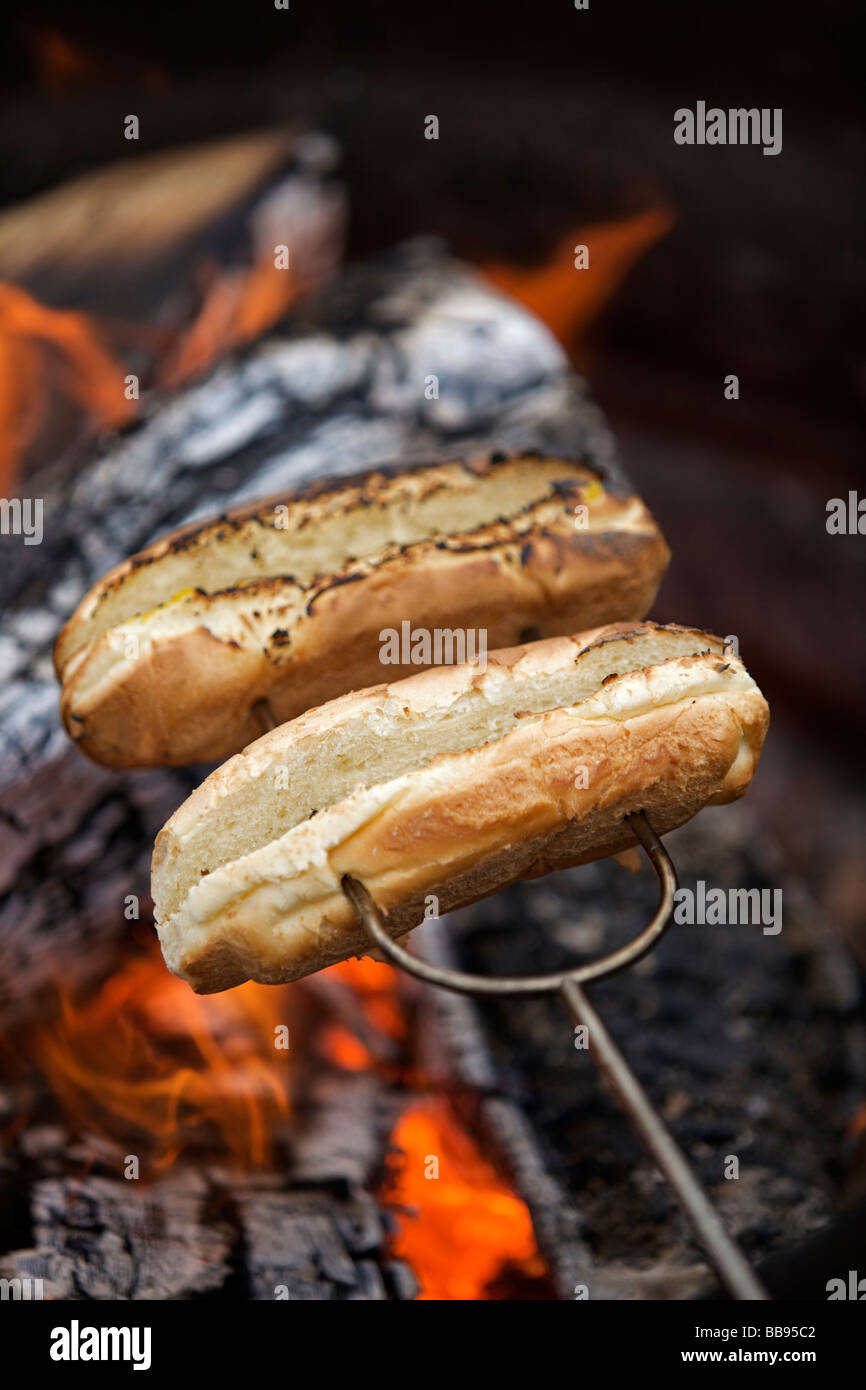 La tostatura di hot dog panini su un falò Foto Stock