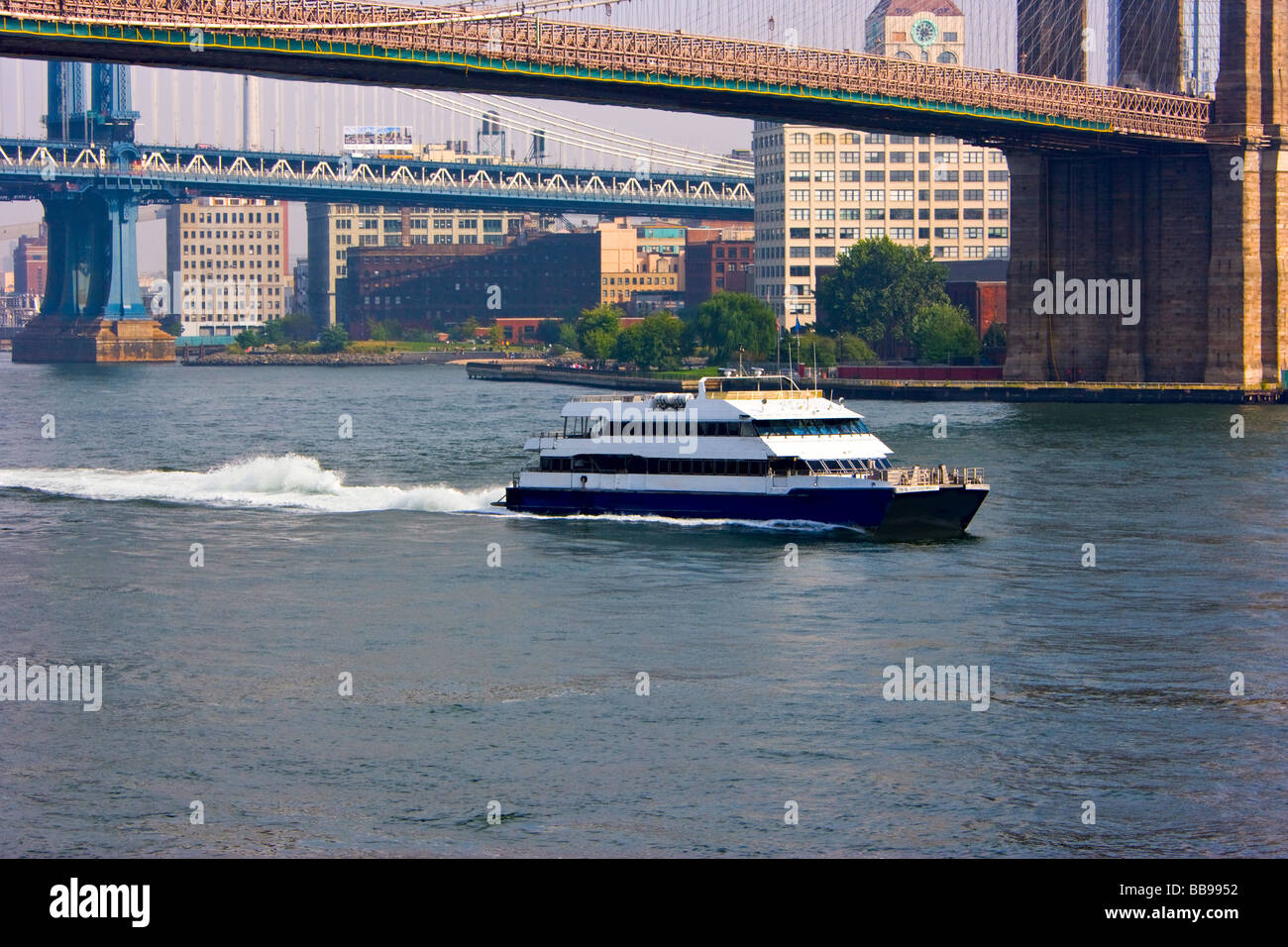 Il traghetto sul Fiume est passando sotto il ponte di Brooklyn a New York City. Foto Stock