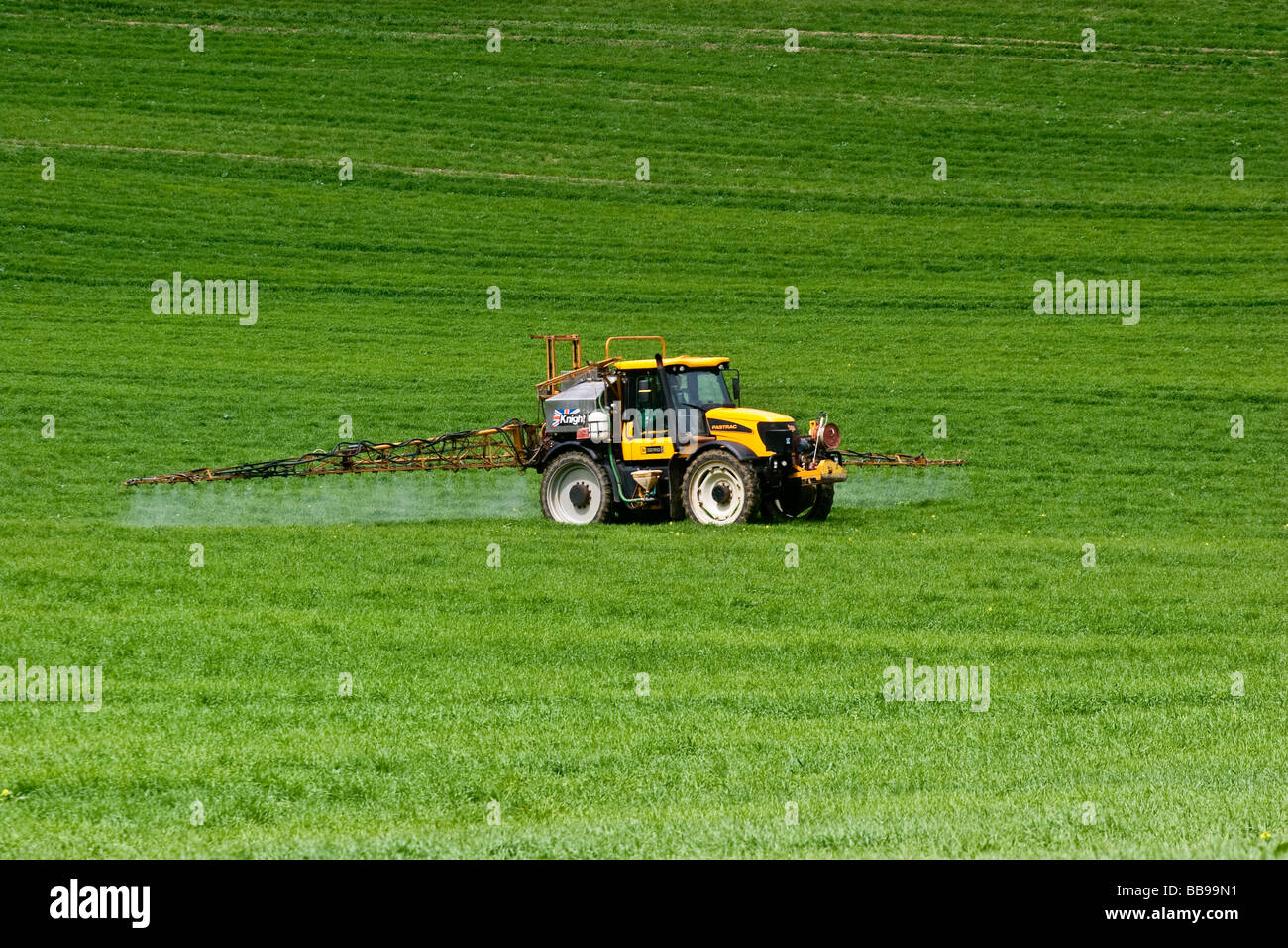 Un JCB Fastrac trattore e Knight irroratrice Weedkller spruzzatura su orzo primaverile Foto Stock