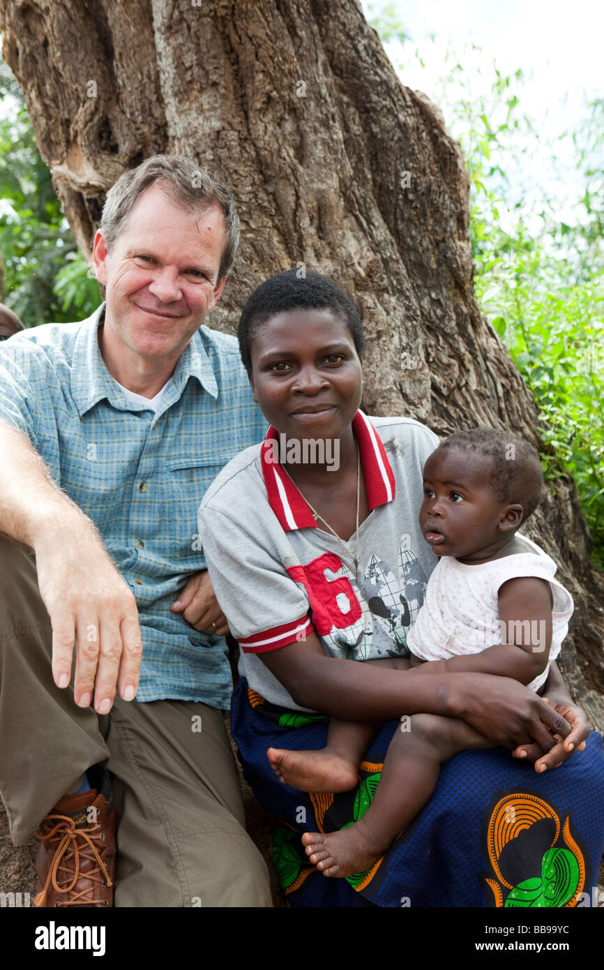 Missionario cristiano Julian Lott con una madre e un bambino nel villaggio di Nyombe, Malawi, Africa Foto Stock