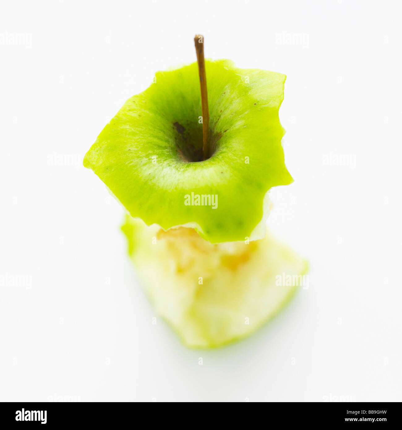 Un apple core isolato su uno sfondo bianco, shot con messa a fuoco poco profonda per sottolineare la forte forma grafica. Foto Stock
