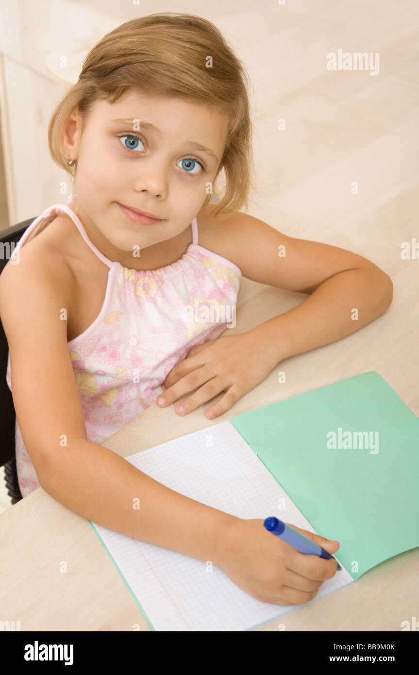 Giovane ragazza caucasica iscritto in un notebook Foto Stock