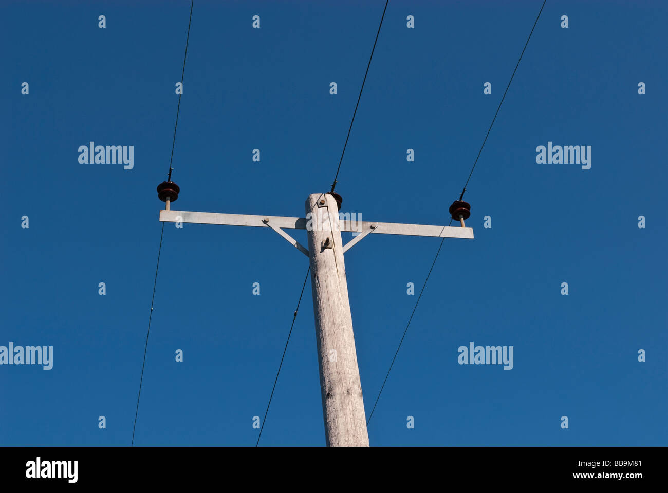 Un palo del telegrafo e fili per comunicazioni elettriche servizi contro un profondo cielo blu Foto Stock