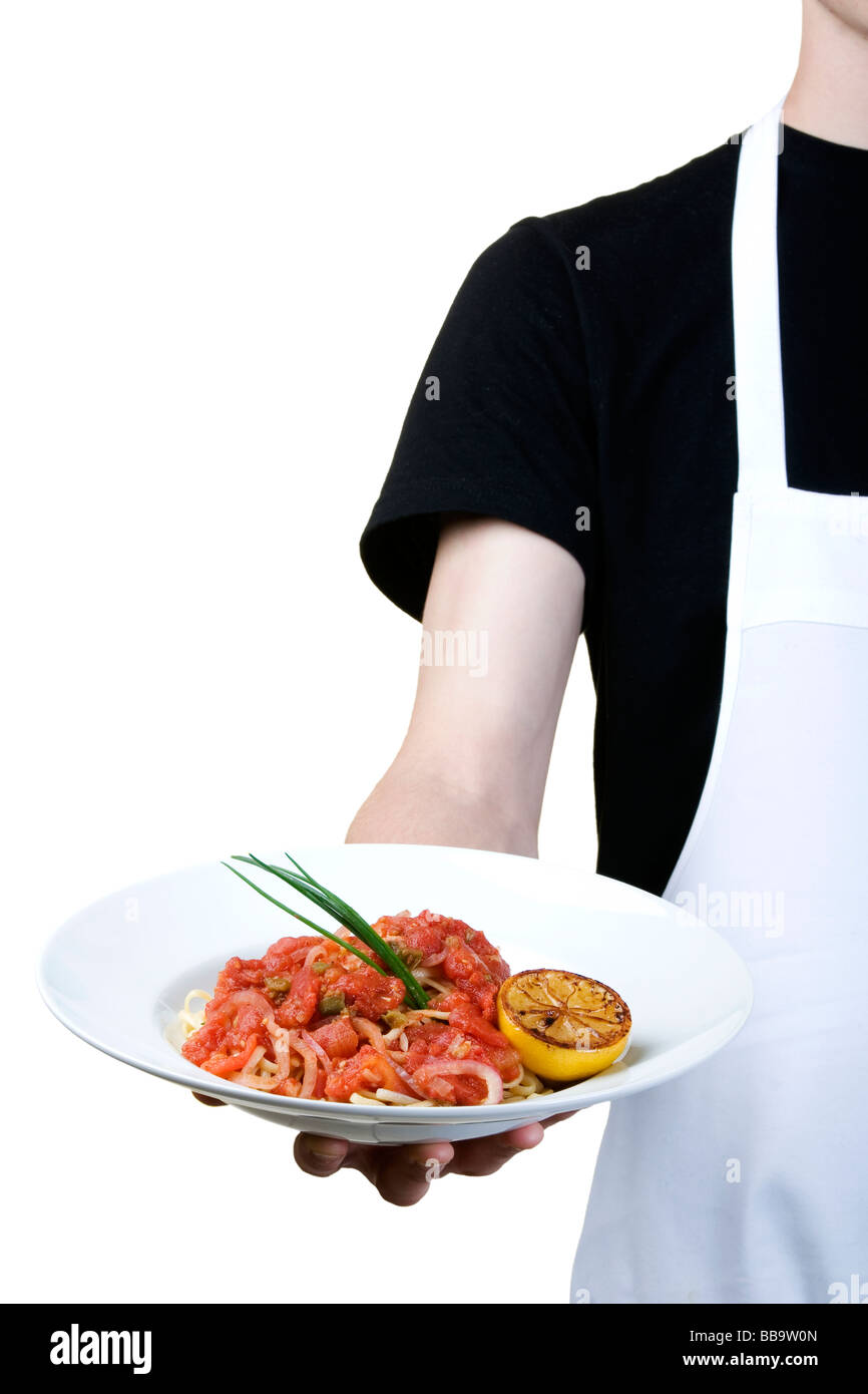 Corpo isolato di cook tenendo un piatto di linguini con salsa di pomodoro Foto Stock