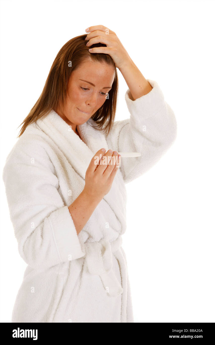 Femmina attraente tenendo un test di gravidanza e guardando sicuri Foto Stock