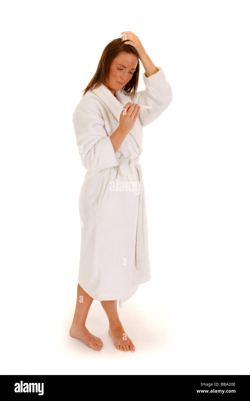 Femmina attraente tenendo un test di gravidanza e guardando sicuri Foto Stock