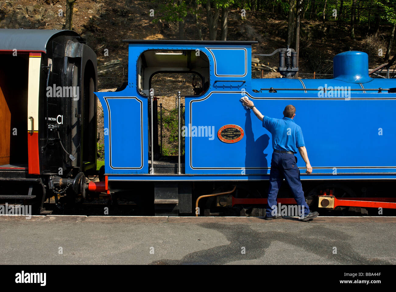 L'uomo pulizia motore, Lakeside & Haverthwaite ferroviarie, South Lakeland, Cumbria, England Regno Unito Foto Stock