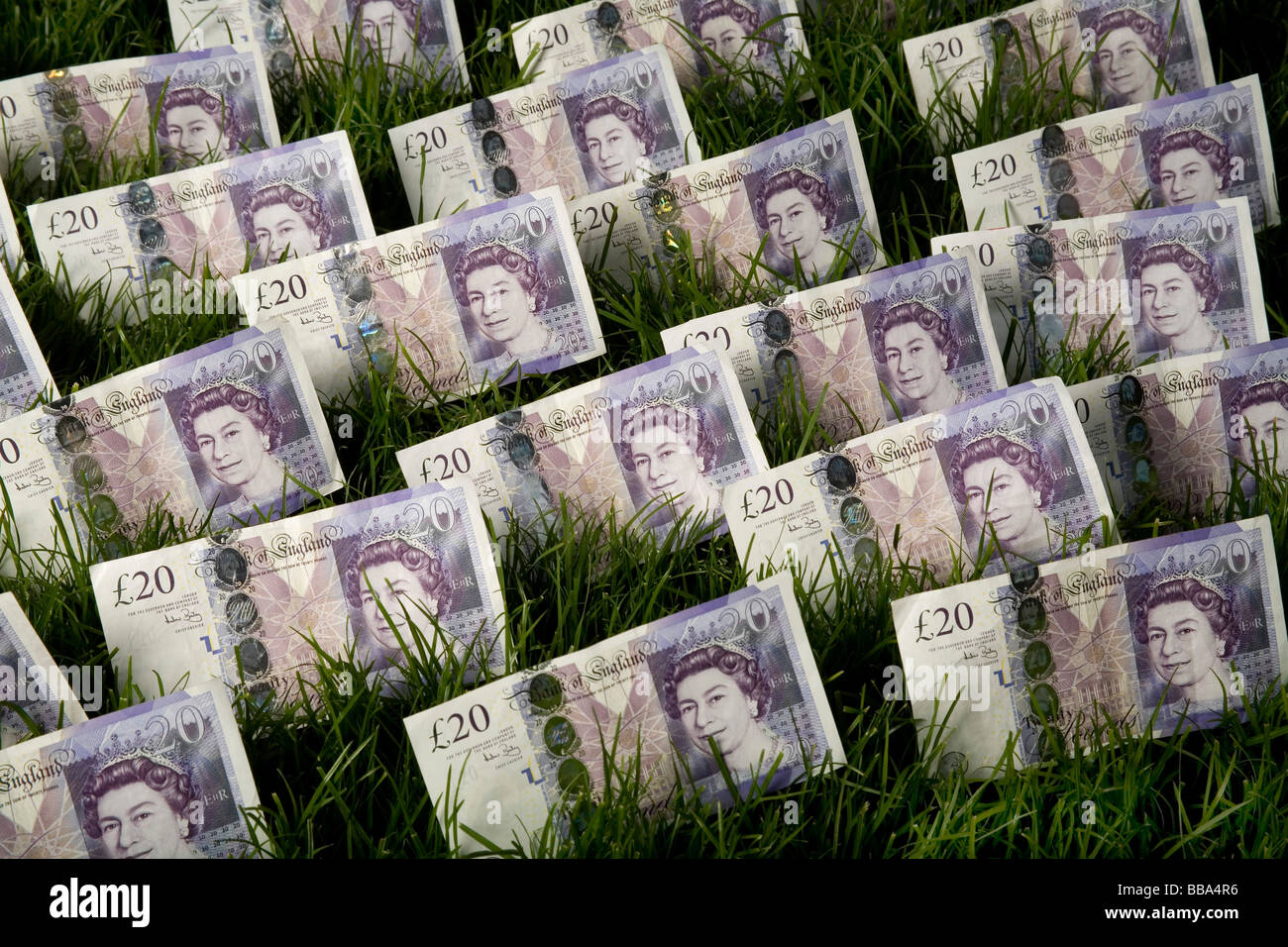 Germogli verdi di recupero venti pound note in un prato verde il denaro su un prato che rappresenta la crescita finanziaria Foto Stock